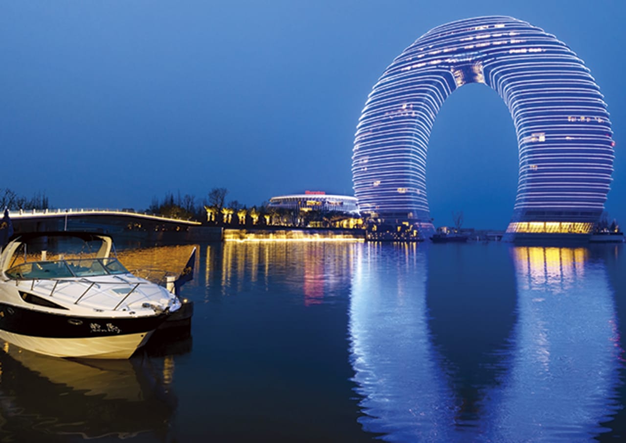 El hotel está construido sobre el Lago Tai y su estructura extraordinaria se parece a una luna, una forma que fue inspirada por los puentes de arco de la arquitectura tradicional China. Por la noche, se crea un espectáculo lumínico impresionante, con luces de distintos colores y formas. Las habitaciones están todas equipadas con alta tecnología, incluyendo, por ejemplo, un panel de control avanzado en el iPad para las luces y las cortinas. El baño en las suites está igual de bien equipado, con los modelos de la colección Khroma de Roca. Los colores inspiradores y personalizados de los productos, y sus acabados texturizados, llevan el baño en un lugar fuera de la monotonía, y le acercan en un sitio donde disfrutar de un maravilloso viaje gracias a la alta tecnología.2