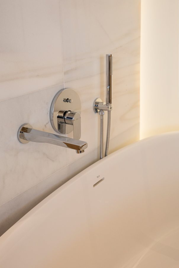 Los baños del Gran Meliá Torre Melina ofrecen una experiencia sofisticada y confortable, realzada por los productos de alta gama de Roca. En las habitaciones Supreme, los huéspedes pueden disfrutar de un exclusivo baño con la original bañera de Stonex® Kauai y la grifería de baño-ducha. Otras habitaciones cuentan con innovadoras soluciones para el espacio de ducha, como los platos de ducha de Stonex® Terran y la grifería termostática T-500, que proporcionan una sensación única en la ducha. Los aseos públicos del hotel cuentan con modernos y funcionales lavabos sobre encimera de la colección Ona, urinarios Mural e inodoros adosados a pared The Gap Round. Los resistentes materiales de Roca Stonex® y Fineceramic® no sólo contribuyen a optimizar los estándares de higiene, sino que también aumentan la eficiencia operativa en todo el hotel, reflejando el compromiso de este establecimiento con la excelencia hotelera.