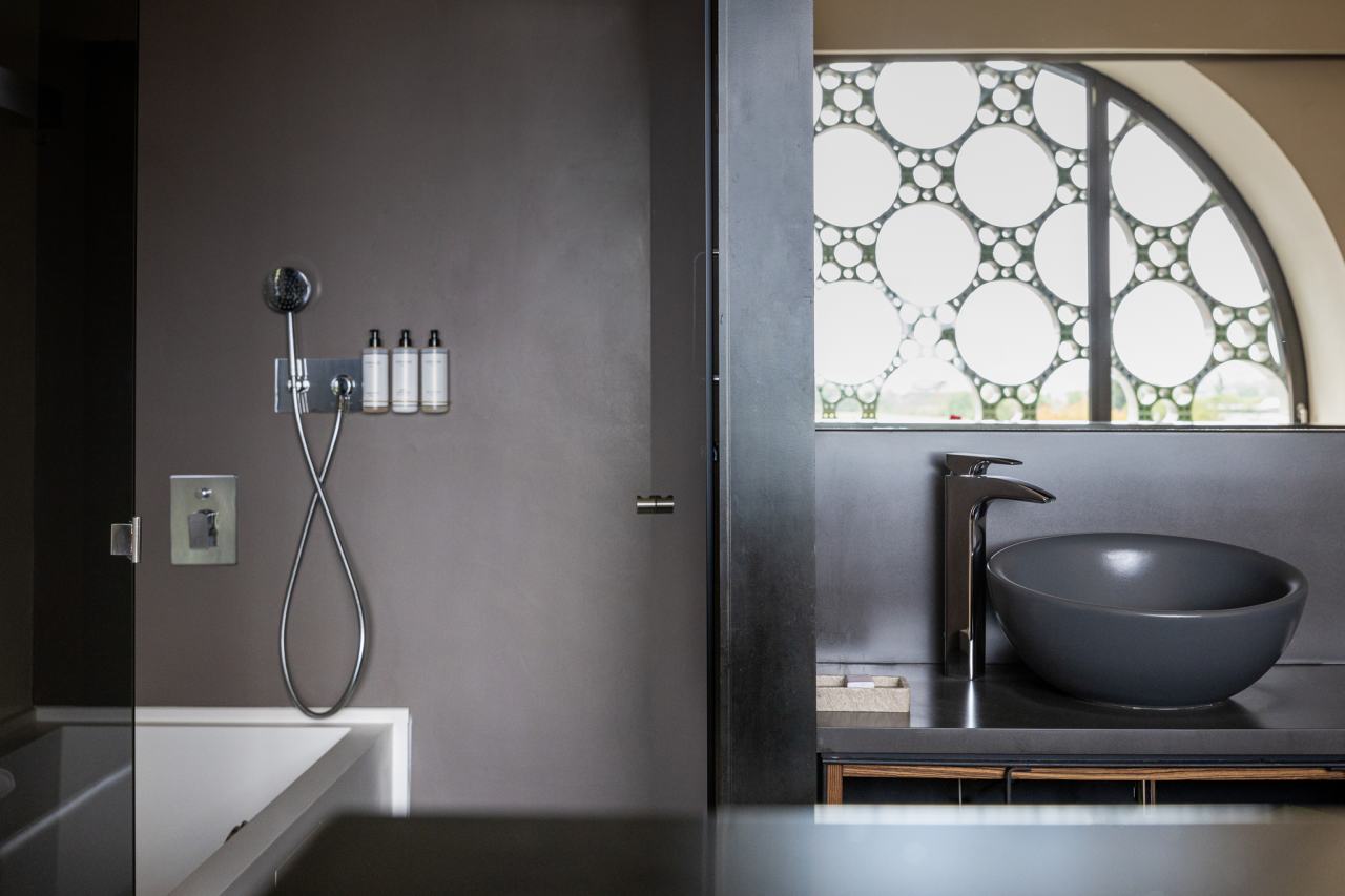 El diseño de este hotel boutique de 13 habitaciones se inspira en el apilado horizontal de las botellas de cava y en la técnica del trencadís de Antoni Gaudí. Las líneas sinuosas, los grandes ventanales circulares y los motivos geométricos, junto con el uso de materiales naturales, crean un conjunto equilibrado en perfecta armonía con el entorno. Los modernos baños de planta abierta cuentan con lavabos Bol en acabado grafito, la elegante grifería de lavabo Thesis y los originales inodoros Happening. La decidida apuesta por la sostenibilidad, patente en el cuidado diseño del edificio y las buenas prácticas sostenibles, también se refleja en los productos Roca, que contribuyen a la eficiencia energética y la durabilidad.7