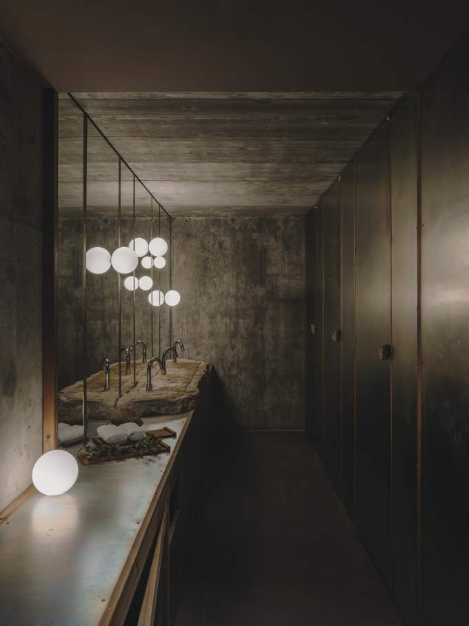 El diseño de Carulla para el restaurante, también denominado Esperit Roca, combina suaves tonos tierra con paredes de hormigón, detalles en piedra y una cálida iluminación para crear un espacio acogedor que transmite una sutil sofisticación. En los espacios de baño se ha optado por el inodoro suspendido Roca Rimless® de la colección Tura, concebida por el diseñador, para lograr una estética unificada. Al igual que el propio restaurante, el diseño escultural del inodoro está inspirado en el paisaje mediterráneo de la región. Otros elementos seleccionados incluyen la grifería electrónica Loft, que se integra a la perfección en los lavabos de piedra. La silueta casi industrial de la grifería complementa la solidez de la piedra y el espacio en penumbra, mientras que la tecnología electrónica aporta eficiencia hídrica y facilidad de uso.1