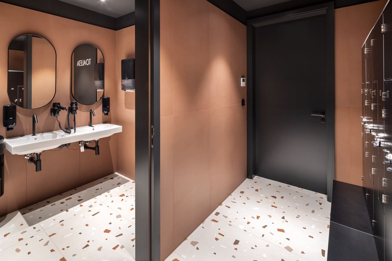 La prioridad en el diseño interior del hotel es garantizar que los huéspedes se vayan con una sonrisa, sintiéndose relajados y completamente satisfechos. Adoptando el enfoque minimalista del hygge, el diseño transmite una agradable sensación de confort a través de una cuidada selección de colores y mobiliario en materiales naturales con suaves curvas y formas orgánicas. En perfecta sintonía con la filosofía hygge, las líneas suaves y las formas redondeadas del lavabo Beyond de color café y del inodoro y bidé Inspira irradian relajación, calidez y armonía. El diseño de la colección Ona, inspirado en la naturaleza, se suma a la estética relajante. Los bidés y lavabos suspendidos contribuyen a crear una sensación de amplitud y equilibrio que evoca la serenidad de los paisajes tranquilos. De esta forma, el confort y el hygge se transmiten a todos los huéspedes del hotel. Los aseos públicos para hombres cuentan con los minimalistas urinarios Proton y los aseos accesibles están equipados con inodoros Access y asas de baño, garantizando un entorno acogedor e inclusivo para todos.4