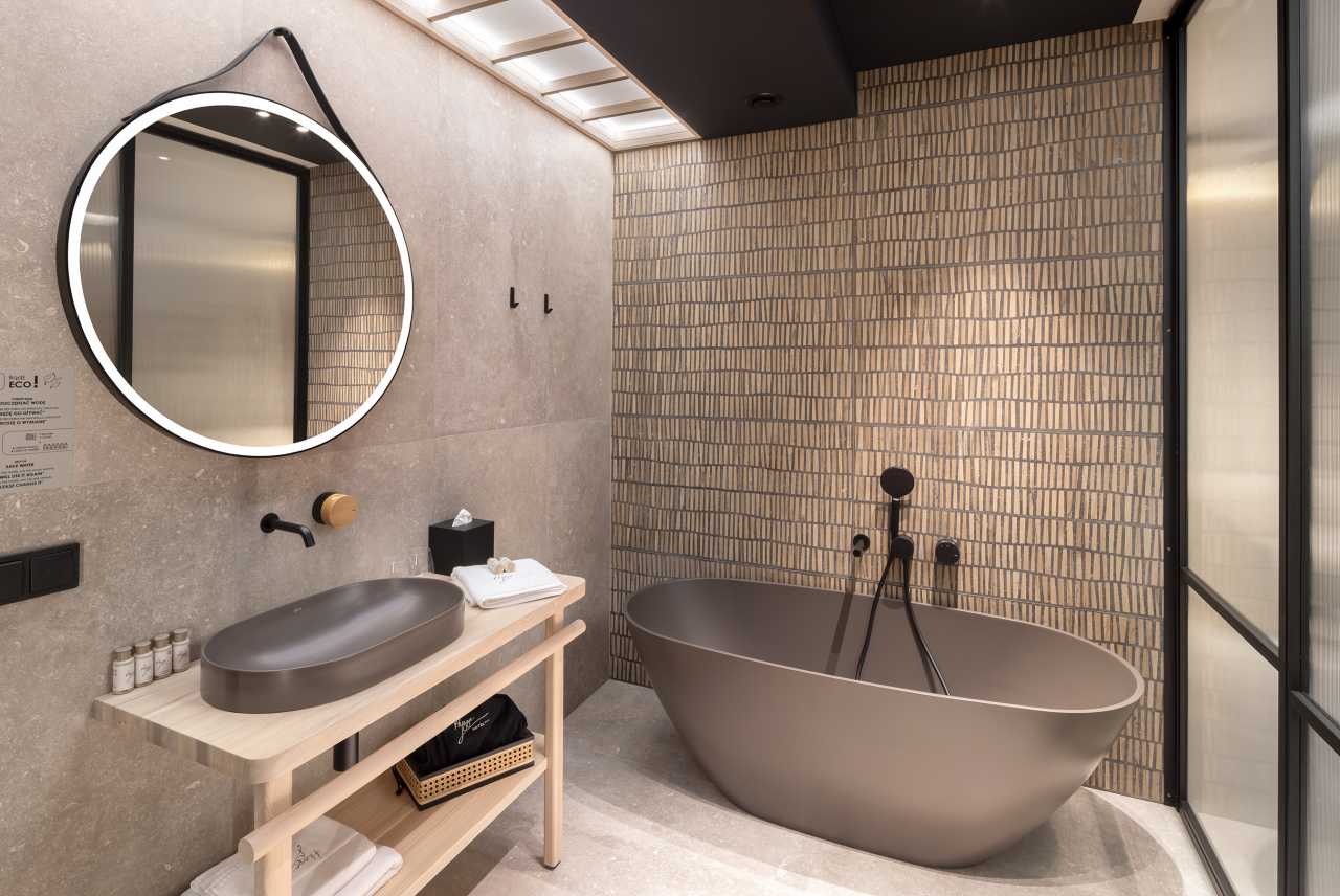 La prioridad en el diseño interior del hotel es garantizar que los huéspedes se vayan con una sonrisa, sintiéndose relajados y completamente satisfechos. Adoptando el enfoque minimalista del hygge, el diseño transmite una agradable sensación de confort a través de una cuidada selección de colores y mobiliario en materiales naturales con suaves curvas y formas orgánicas. En perfecta sintonía con la filosofía hygge, las líneas suaves y las formas redondeadas del lavabo Beyond de color café y del inodoro y bidé Inspira irradian relajación, calidez y armonía. El diseño de la colección Ona, inspirado en la naturaleza, se suma a la estética relajante. Los bidés y lavabos suspendidos contribuyen a crear una sensación de amplitud y equilibrio que evoca la serenidad de los paisajes tranquilos. De esta forma, el confort y el hygge se transmiten a todos los huéspedes del hotel. Los aseos públicos para hombres cuentan con los minimalistas urinarios Proton y los aseos accesibles están equipados con inodoros Access y asas de baño, garantizando un entorno acogedor e inclusivo para todos.21