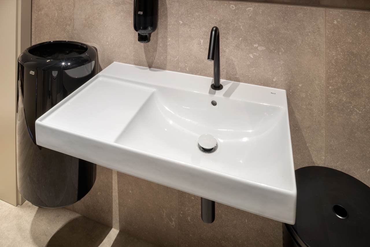 La prioridad en el diseño interior del hotel es garantizar que los huéspedes se vayan con una sonrisa, sintiéndose relajados y completamente satisfechos. Adoptando el enfoque minimalista del hygge, el diseño transmite una agradable sensación de confort a través de una cuidada selección de colores y mobiliario en materiales naturales con suaves curvas y formas orgánicas. En perfecta sintonía con la filosofía hygge, las líneas suaves y las formas redondeadas del lavabo Beyond de color café y del inodoro y bidé Inspira irradian relajación, calidez y armonía. El diseño de la colección Ona, inspirado en la naturaleza, se suma a la estética relajante. Los bidés y lavabos suspendidos contribuyen a crear una sensación de amplitud y equilibrio que evoca la serenidad de los paisajes tranquilos. De esta forma, el confort y el hygge se transmiten a todos los huéspedes del hotel. Los aseos públicos para hombres cuentan con los minimalistas urinarios Proton y los aseos accesibles están equipados con inodoros Access y asas de baño, garantizando un entorno acogedor e inclusivo para todos.41