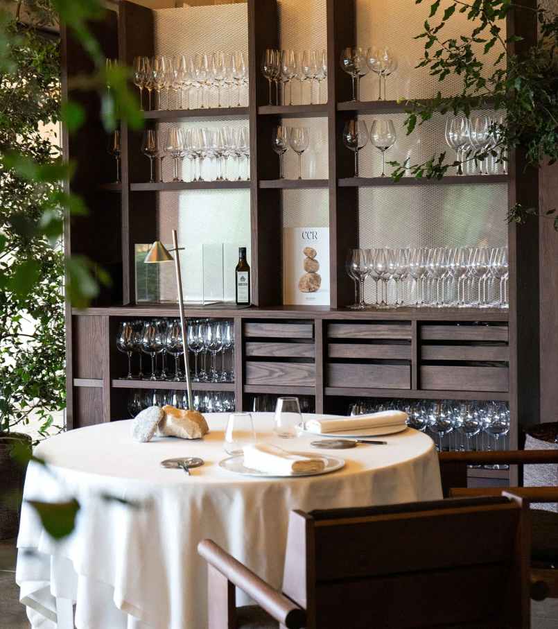 El diseño de Carulla para el restaurante, también denominado Esperit Roca, combina suaves tonos tierra con paredes de hormigón, detalles en piedra y una cálida iluminación para crear un espacio acogedor que transmite una sutil sofisticación. En los espacios de baño se ha optado por el inodoro suspendido Roca Rimless® de la colección Tura, concebida por el diseñador, para lograr una estética unificada. Al igual que el propio restaurante, el diseño escultural del inodoro está inspirado en el paisaje mediterráneo de la región. Otros elementos seleccionados incluyen la grifería electrónica Loft, que se integra a la perfección en los lavabos de piedra. La silueta casi industrial de la grifería complementa la solidez de la piedra y el espacio en penumbra, mientras que la tecnología electrónica aporta eficiencia hídrica y facilidad de uso.5