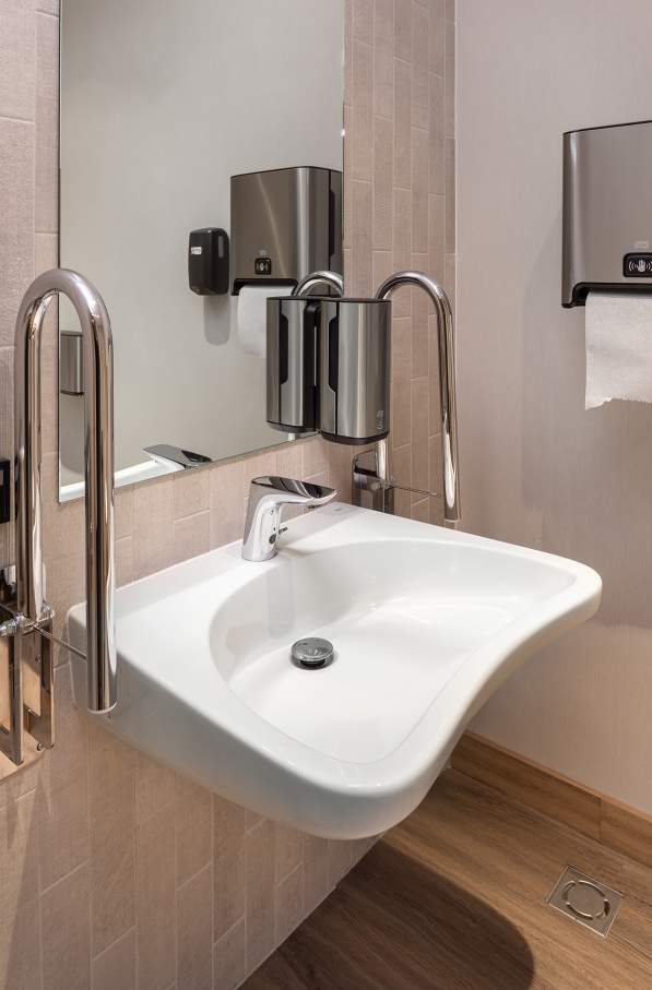 El interiorismo, obra de Tremend Studio, presenta un diseño armonioso caracterizado por el uso de tonos cálidos y naturales con detalles en madera que crean un ambiente agradable y relajado. Los baños de las habitaciones cuentan con confortables bañeras encastradas o duchas walk-in y mamparas de cristal, que generan una sensación de amplitud y espaciosidad. La atmósfera exclusiva y acogedora de estos baños se logra gracias a los muebles con acabados en madera, los lavabos Diverta sobre encimera y los inodoros The Gap Rimless. Por otro lado, los baños públicos también destacan por su minimalismo, con una planta diáfana en la que cobran protagonismo los lavabos Diverta y los urinarios Hall. Los espejos con iluminación LED integrada realzan el espacio con un suave resplandor y añaden al mismo tiempo un toque de sofisticación.3