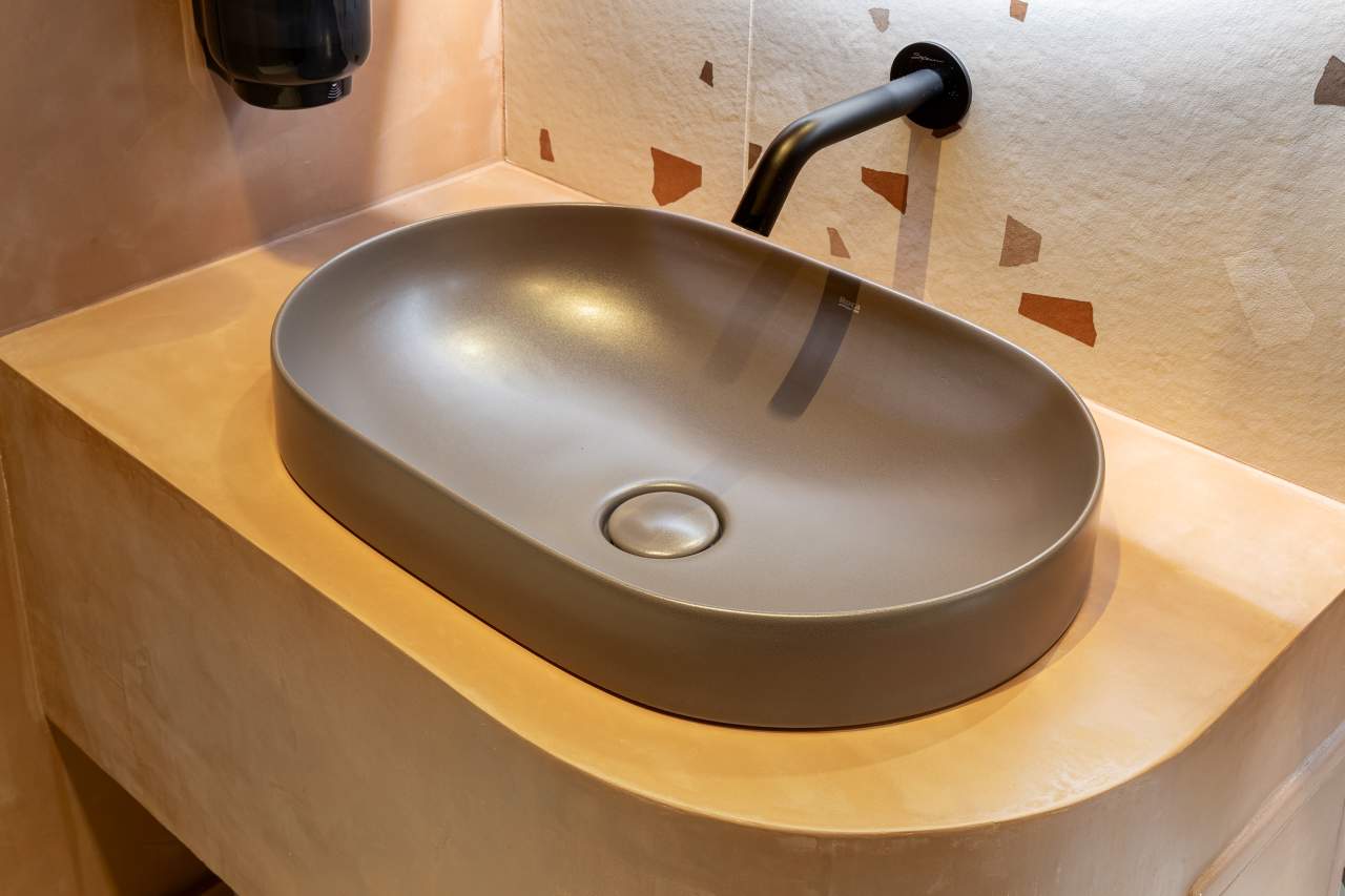 La prioridad en el diseño interior del hotel es garantizar que los huéspedes se vayan con una sonrisa, sintiéndose relajados y completamente satisfechos. Adoptando el enfoque minimalista del hygge, el diseño transmite una agradable sensación de confort a través de una cuidada selección de colores y mobiliario en materiales naturales con suaves curvas y formas orgánicas. En perfecta sintonía con la filosofía hygge, las líneas suaves y las formas redondeadas del lavabo Beyond de color café y del inodoro y bidé Inspira irradian relajación, calidez y armonía. El diseño de la colección Ona, inspirado en la naturaleza, se suma a la estética relajante. Los bidés y lavabos suspendidos contribuyen a crear una sensación de amplitud y equilibrio que evoca la serenidad de los paisajes tranquilos. De esta forma, el confort y el hygge se transmiten a todos los huéspedes del hotel. Los aseos públicos para hombres cuentan con los minimalistas urinarios Proton y los aseos accesibles están equipados con inodoros Access y asas de baño, garantizando un entorno acogedor e inclusivo para todos.44