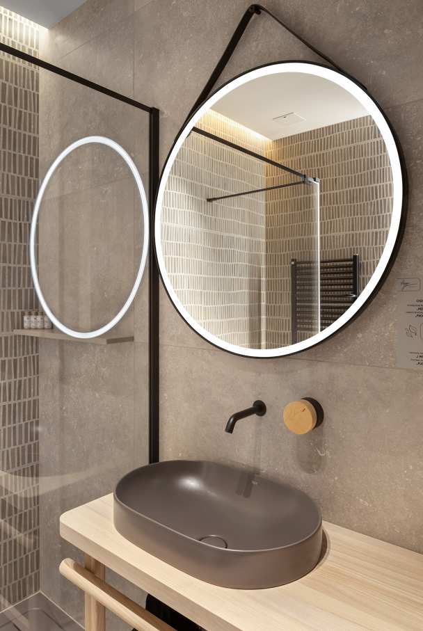 La prioridad en el diseño interior del hotel es garantizar que los huéspedes se vayan con una sonrisa, sintiéndose relajados y completamente satisfechos. Adoptando el enfoque minimalista del hygge, el diseño transmite una agradable sensación de confort a través de una cuidada selección de colores y mobiliario en materiales naturales con suaves curvas y formas orgánicas. En perfecta sintonía con la filosofía hygge, las líneas suaves y las formas redondeadas del lavabo Beyond de color café y del inodoro y bidé Inspira irradian relajación, calidez y armonía. El diseño de la colección Ona, inspirado en la naturaleza, se suma a la estética relajante. Los bidés y lavabos suspendidos contribuyen a crear una sensación de amplitud y equilibrio que evoca la serenidad de los paisajes tranquilos. De esta forma, el confort y el hygge se transmiten a todos los huéspedes del hotel. Los aseos públicos para hombres cuentan con los minimalistas urinarios Proton y los aseos accesibles están equipados con inodoros Access y asas de baño, garantizando un entorno acogedor e inclusivo para todos.5