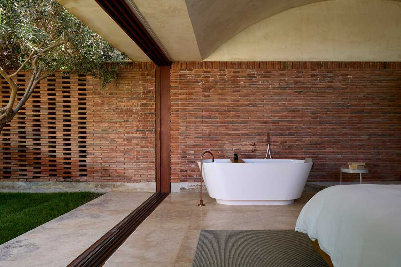 La distribución de Casa IV transforma el baño en un elemento fluido del espacio vital, contribuyendo a mejorar la experiencia de los habitantes de la vivienda. La incorporación de la bañera, el inodoro y el lavabo sobre encimera de la colección Tura genera una sensación de calma y sofisticación, mientras que la grifería Stripes de la colección Nu introduce un toque de dinamismo. La bañera trasciende lo funcional, convirtiéndose en el centro de atención del dormitorio y en un símbolo del estilo de vida mediterráneo. Esta vivienda es un ejemplo de cómo los productos Roca mejoran la experiencia de los usuarios, creando una mezcla perfecta de funcionalidad y diseño, en línea con la filosofía del proyecto, basada en la elegancia discreta y en los detalles cuidadosamente escogidos.18