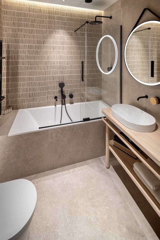 La prioridad en el diseño interior del hotel es garantizar que los huéspedes se vayan con una sonrisa, sintiéndose relajados y completamente satisfechos. Adoptando el enfoque minimalista del hygge, el diseño transmite una agradable sensación de confort a través de una cuidada selección de colores y mobiliario en materiales naturales con suaves curvas y formas orgánicas. En perfecta sintonía con la filosofía hygge, las líneas suaves y las formas redondeadas del lavabo Beyond de color café y del inodoro y bidé Inspira irradian relajación, calidez y armonía. El diseño de la colección Ona, inspirado en la naturaleza, se suma a la estética relajante. Los bidés y lavabos suspendidos contribuyen a crear una sensación de amplitud y equilibrio que evoca la serenidad de los paisajes tranquilos. De esta forma, el confort y el hygge se transmiten a todos los huéspedes del hotel. Los aseos públicos para hombres cuentan con los minimalistas urinarios Proton y los aseos accesibles están equipados con inodoros Access y asas de baño, garantizando un entorno acogedor e inclusivo para todos.30