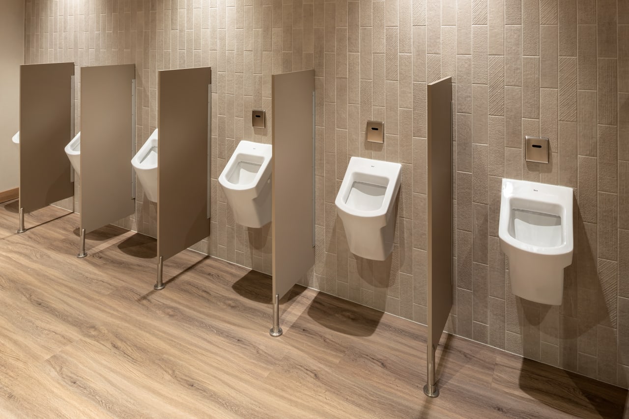 El interiorismo, obra de Tremend Studio, presenta un diseño armonioso caracterizado por el uso de tonos cálidos y naturales con detalles en madera que crean un ambiente agradable y relajado. Los baños de las habitaciones cuentan con confortables bañeras encastradas o duchas walk-in y mamparas de cristal, que generan una sensación de amplitud y espaciosidad. La atmósfera exclusiva y acogedora de estos baños se logra gracias a los muebles con acabados en madera, los lavabos Diverta sobre encimera y los inodoros The Gap Rimless. Por otro lado, los baños públicos también destacan por su minimalismo, con una planta diáfana en la que cobran protagonismo los lavabos Diverta y los urinarios Hall. Los espejos con iluminación LED integrada realzan el espacio con un suave resplandor y añaden al mismo tiempo un toque de sofisticación.