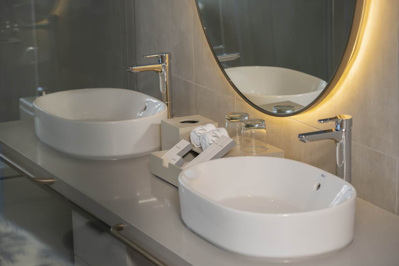 El diseño del hotel Akara Pattaya gira en torno a la dualidad entre serenidad y energía. Las soluciones de baño Roca fueron escogidas por su capacidad para adaptarse a esta transformación gracias a su funcionalidad, versatilidad y diseño elegante. El inodoro Inspira, el lavabo The Gap Round y la grifería L20 destacan por su minimalismo que transmite una sensación de tranquilidad y armonía. La aparente sencillez de las griferías Loft y Atlas contribuye a acentuar este ambiente de serenidad, logrando que los huéspedes se vean transportados a un oasis de sofisticación, ya sea bañado por la luminosidad del día o por la energía nocturna. Con el fin de contribuir aún más al bienestar de los huéspedes, la bañera encastrada Palma y la grifería de pie de baño-ducha Escuadra crean un lujoso santuario, mientras que el rociador Raindream y la ducha de mano Plenum ofrecen una experiencia de ducha envolvente.1