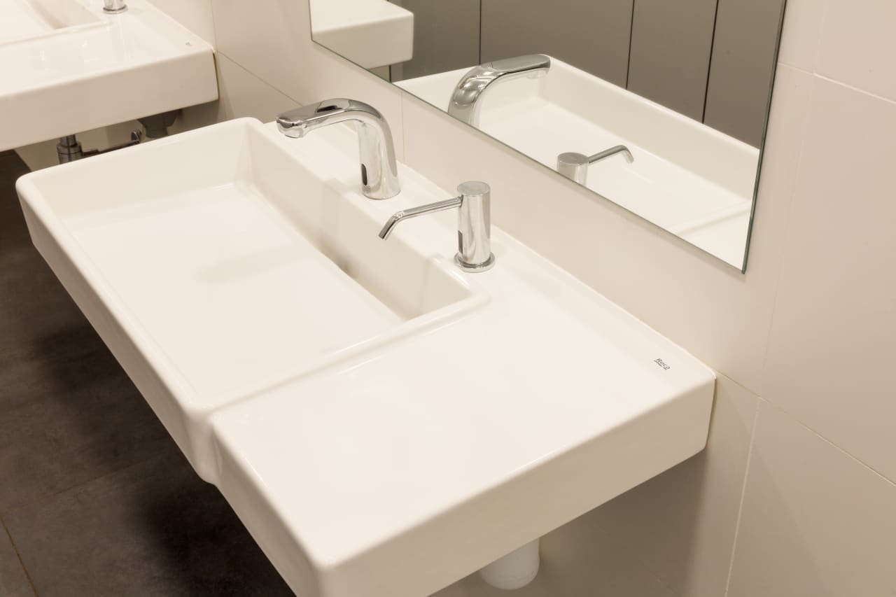 Con el fin de adaptar los baños a las necesidades actuales y respetar la integridad del edificio, los productos seleccionados deben transmitir los ideales contemporáneos de su arquitectura y ser accesibles e inclusivos. El diseño lineal y estructurado de los lavabos murales y las suaves curvas y volúmenes apilados de los inodoros suspendidos Roca Rimless® evocan una simplicidad atemporal y se hacen eco de los ideales modernistas del edificio de Sert. La colección Access, adecuada para todo tipo de usuarios, ha sido otra incorporación esencial a los baños, incluidos los asientos y tapas de inodoro, los espejos basculantes y los asientos de ducha abatibles. La elección de los dispensadores de toallas y las papeleras de la colección Public han contribuido a una mayor funcionalidad del espacio.12