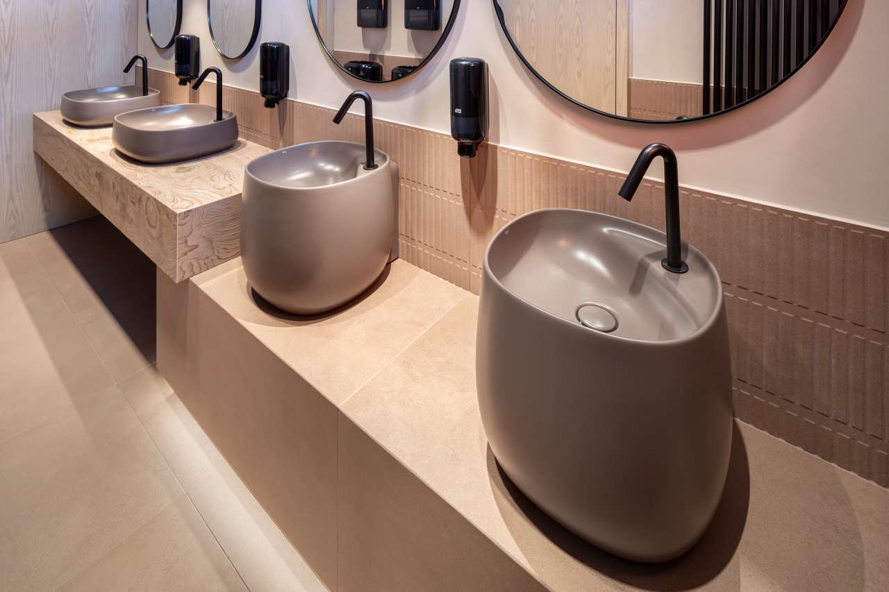 La prioridad en el diseño interior del hotel es garantizar que los huéspedes se vayan con una sonrisa, sintiéndose relajados y completamente satisfechos. Adoptando el enfoque minimalista del hygge, el diseño transmite una agradable sensación de confort a través de una cuidada selección de colores y mobiliario en materiales naturales con suaves curvas y formas orgánicas. En perfecta sintonía con la filosofía hygge, las líneas suaves y las formas redondeadas del lavabo Beyond de color café y del inodoro y bidé Inspira irradian relajación, calidez y armonía. El diseño de la colección Ona, inspirado en la naturaleza, se suma a la estética relajante. Los bidés y lavabos suspendidos contribuyen a crear una sensación de amplitud y equilibrio que evoca la serenidad de los paisajes tranquilos. De esta forma, el confort y el hygge se transmiten a todos los huéspedes del hotel. Los aseos públicos para hombres cuentan con los minimalistas urinarios Proton y los aseos accesibles están equipados con inodoros Access y asas de baño, garantizando un entorno acogedor e inclusivo para todos.40