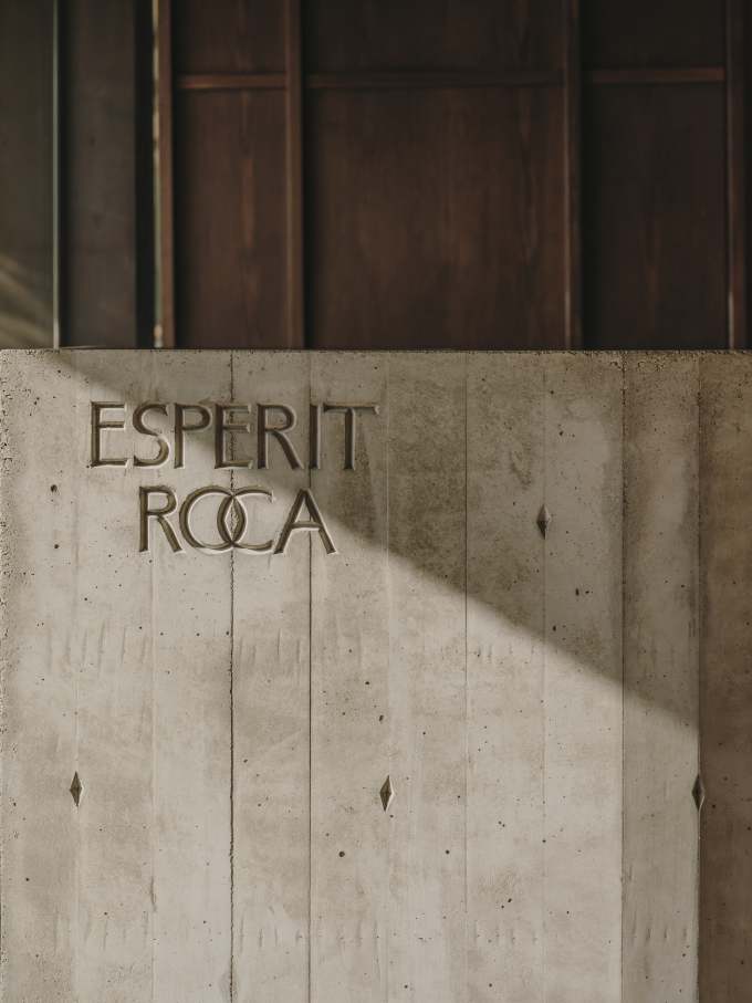 El diseño de Carulla para el restaurante, también denominado Esperit Roca, combina suaves tonos tierra con paredes de hormigón, detalles en piedra y una cálida iluminación para crear un espacio acogedor que transmite una sutil sofisticación. En los espacios de baño se ha optado por el inodoro suspendido Roca Rimless® de la colección Tura, concebida por el diseñador, para lograr una estética unificada. Al igual que el propio restaurante, el diseño escultural del inodoro está inspirado en el paisaje mediterráneo de la región. Otros elementos seleccionados incluyen la grifería electrónica Loft, que se integra a la perfección en los lavabos de piedra. La silueta casi industrial de la grifería complementa la solidez de la piedra y el espacio en penumbra, mientras que la tecnología electrónica aporta eficiencia hídrica y facilidad de uso.4