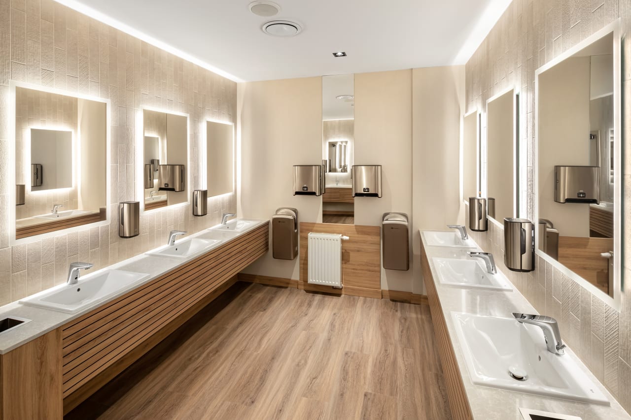 El interiorismo, obra de Tremend Studio, presenta un diseño armonioso caracterizado por el uso de tonos cálidos y naturales con detalles en madera que crean un ambiente agradable y relajado. Los baños de las habitaciones cuentan con confortables bañeras encastradas o duchas walk-in y mamparas de cristal, que generan una sensación de amplitud y espaciosidad. La atmósfera exclusiva y acogedora de estos baños se logra gracias a los muebles con acabados en madera, los lavabos Diverta sobre encimera y los inodoros The Gap Rimless. Por otro lado, los baños públicos también destacan por su minimalismo, con una planta diáfana en la que cobran protagonismo los lavabos Diverta y los urinarios Hall. Los espejos con iluminación LED integrada realzan el espacio con un suave resplandor y añaden al mismo tiempo un toque de sofisticación.9