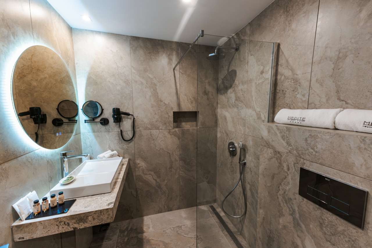 Los baños del hotel cumplen con los más altos estándares de la hostelería moderna gracias a la amplia gama de productos Roca presente en el establecimiento. Las duchas de mano Stella y los rociadores Rainsense ofrecen una experiencia envolvente en la ducha y un ambiente similar al de un spa, mientras los inodoros The Gap, los lavabos Horizon y la grifería Victoria Plus destacan por su funcionalidad y fácil manejo. Estas soluciones de baño, de gran durabilidad y un diseño moderno, logran crear espacios uniformes y elegantes que reflejan el compromiso del complejo hotelero de garantizar a sus huéspedes una experiencia relajante y reparadora.1