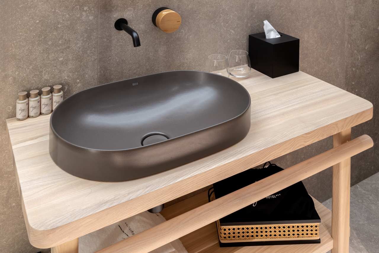 La prioridad en el diseño interior del hotel es garantizar que los huéspedes se vayan con una sonrisa, sintiéndose relajados y completamente satisfechos. Adoptando el enfoque minimalista del hygge, el diseño transmite una agradable sensación de confort a través de una cuidada selección de colores y mobiliario en materiales naturales con suaves curvas y formas orgánicas. En perfecta sintonía con la filosofía hygge, las líneas suaves y las formas redondeadas del lavabo Beyond de color café y del inodoro y bidé Inspira irradian relajación, calidez y armonía. El diseño de la colección Ona, inspirado en la naturaleza, se suma a la estética relajante. Los bidés y lavabos suspendidos contribuyen a crear una sensación de amplitud y equilibrio que evoca la serenidad de los paisajes tranquilos. De esta forma, el confort y el hygge se transmiten a todos los huéspedes del hotel. Los aseos públicos para hombres cuentan con los minimalistas urinarios Proton y los aseos accesibles están equipados con inodoros Access y asas de baño, garantizando un entorno acogedor e inclusivo para todos.34