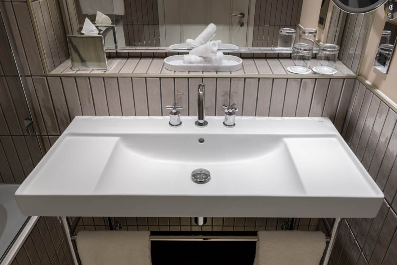 El inodoro suspendido Rimless® y el lavabo de Fineceramic®, ambos de la colección Ona, han sido seleccionados por su diseño funcional y su innovadora tecnología. El primero mejora la higiene y la eficiencia espacial, mientras que el segundo ofrece la máxima durabilidad y un diseño sofisticado. Por otro lado, el plato de ducha Pyros, fabricado en Stonex®, destaca por su diseño extraplano y su discreto desagüe lineal, elevando así la estética del espacio de baño. Esta colaboración es el ejemplo perfecto de cómo el diseño y la tecnología de vanguardia logran realzar los espacios históricos, creando una sinergia atemporal entre la elegancia victoriana y el confort más actual.4