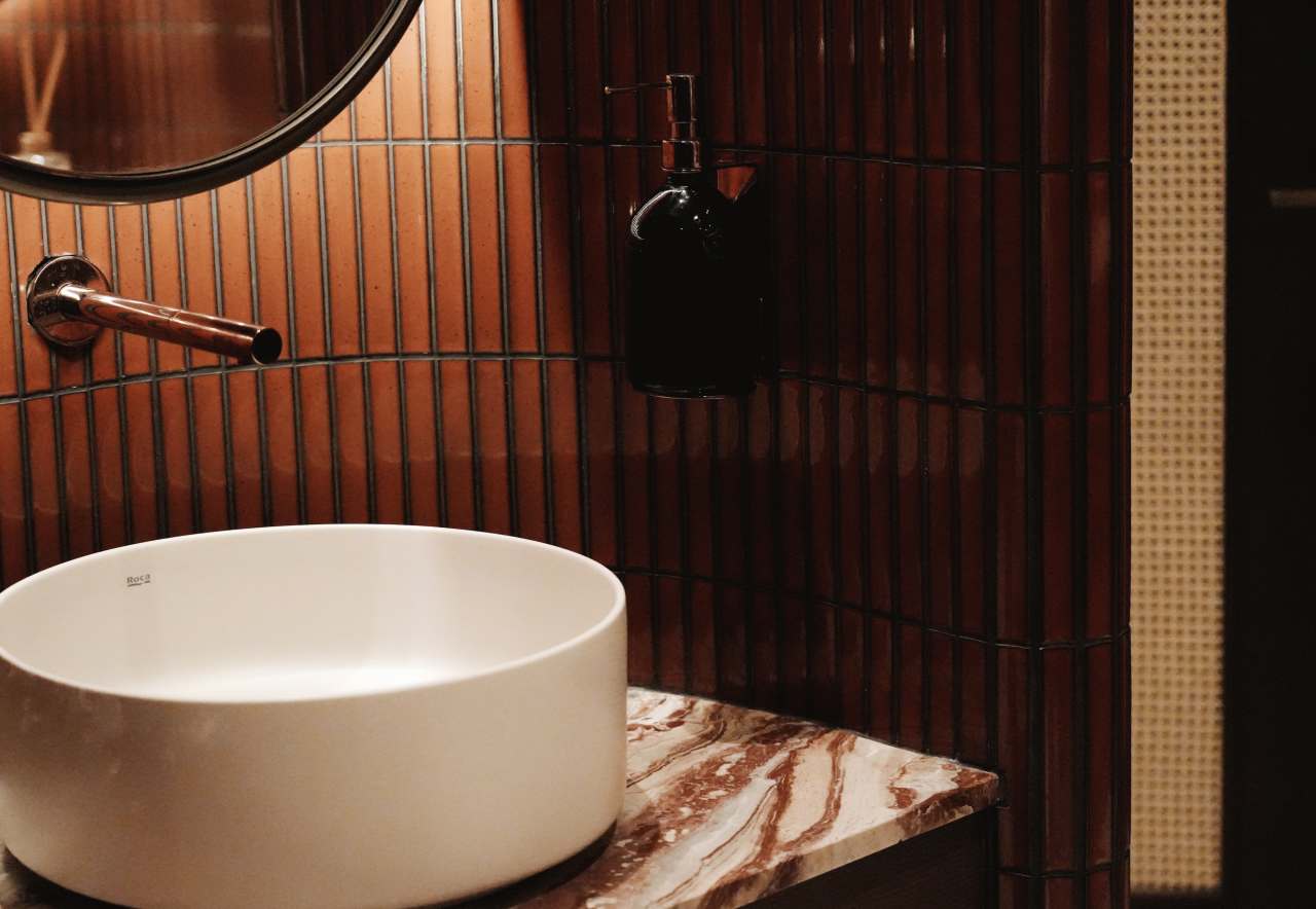 Los espacios de baño son las zonas más íntimas del restaurante y en ellos se ha optado por un diseño de líneas curvas que invita al confort. El lavabo sobre encimera de Fineceramic® Inspira Round ofrece un contrapunto orgánico a las singulares paredes curvas de los baños. La grifería electrónica de lavabo L30-E añade un plus de diseño al espacio y garantiza la eficiencia hídrica, en línea con el concepto del «Árbol de la vida». Entre los accesorios se encuentran la percha Cubica y el escobillero de pared mural Victoria, modelos minimalistas y discretos que ofrecen la máxima funcionalidad. Por otro lado, el inodoro suspendido Rimless Dama, con asiento con caída amortiguada y placa de accionamiento dual In-Wall PL10 (One), aporta un toque de modernidad y complementa el estilo acogedor y natural del espacio de baño.2