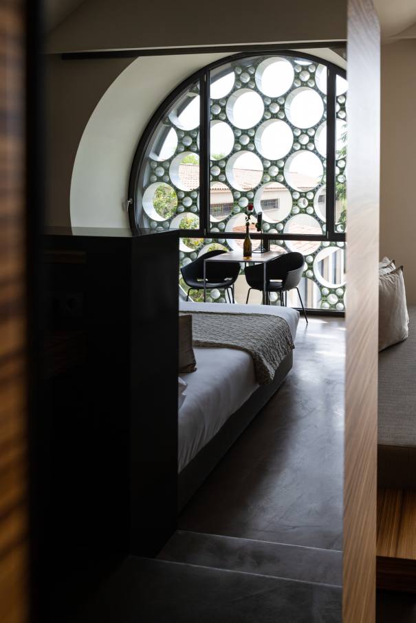 El diseño de este hotel boutique de 13 habitaciones se inspira en el apilado horizontal de las botellas de cava y en la técnica del trencadís de Antoni Gaudí. Las líneas sinuosas, los grandes ventanales circulares y los motivos geométricos, junto con el uso de materiales naturales, crean un conjunto equilibrado en perfecta armonía con el entorno. Los modernos baños de planta abierta cuentan con lavabos Bol en acabado grafito, la elegante grifería de lavabo Thesis y los originales inodoros Happening. La decidida apuesta por la sostenibilidad, patente en el cuidado diseño del edificio y las buenas prácticas sostenibles, también se refleja en los productos Roca, que contribuyen a la eficiencia energética y la durabilidad.2