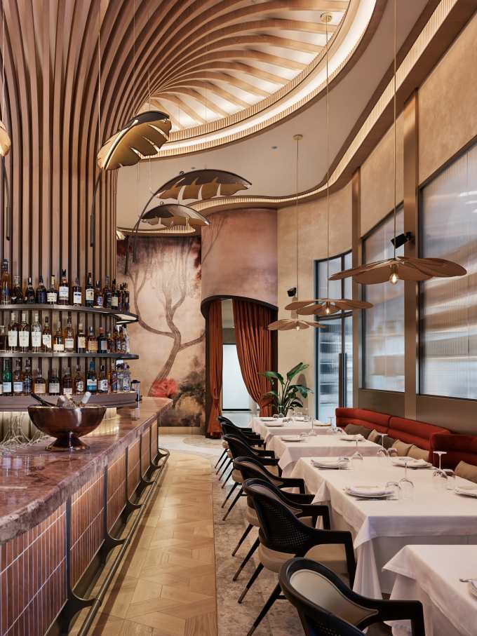 Los espacios de baño son las zonas más íntimas del restaurante y en ellos se ha optado por un diseño de líneas curvas que invita al confort. El lavabo sobre encimera de Fineceramic® Inspira Round ofrece un contrapunto orgánico a las singulares paredes curvas de los baños. La grifería electrónica de lavabo L30-E añade un plus de diseño al espacio y garantiza la eficiencia hídrica, en línea con el concepto del «Árbol de la vida». Entre los accesorios se encuentran la percha Cubica y el escobillero de pared mural Victoria, modelos minimalistas y discretos que ofrecen la máxima funcionalidad. Por otro lado, el inodoro suspendido Rimless Dama, con asiento con caída amortiguada y placa de accionamiento dual In-Wall PL10 (One), aporta un toque de modernidad y complementa el estilo acogedor y natural del espacio de baño.11