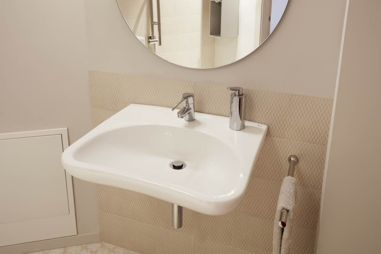 La fundación ofrece atención y apoyo gratuitos a los pacientes de cáncer y a sus familias. El diseño se integra perfectamente en el entorno, con zonas comunes y una acogedora planta baja en forma de abanico con grandes ventanales que dan al jardín. Esta colaboración es una muestra del compromiso con la mejora de la sociedad a través del bienestar y la innovación, que se refleja en la cuidada selección de productos Roca. Entre ellos destacan los lavabos Sofia, combinados con la grifería Lanta y los espejos Luna, y los inodoros Meridian, complementados con placas de accionamiento PL6 Dual, así como griferías de las colecciones Access y Victoria Pro, seleccionadas por su ergonomía. Todos los productos encajan a la perfección con la estética general del centro, que combina tonos neutros relajantes con vivos detalles para fomentar el descanso y el optimismo.6