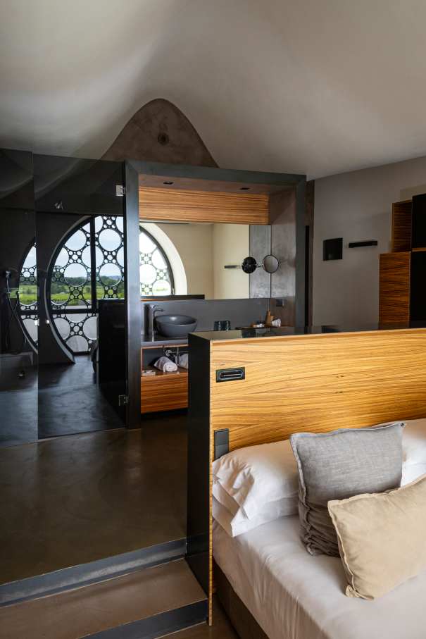 El diseño de este hotel boutique de 13 habitaciones se inspira en el apilado horizontal de las botellas de cava y en la técnica del trencadís de Antoni Gaudí. Las líneas sinuosas, los grandes ventanales circulares y los motivos geométricos, junto con el uso de materiales naturales, crean un conjunto equilibrado en perfecta armonía con el entorno. Los modernos baños de planta abierta cuentan con lavabos Bol en acabado grafito, la elegante grifería de lavabo Thesis y los originales inodoros Happening. La decidida apuesta por la sostenibilidad, patente en el cuidado diseño del edificio y las buenas prácticas sostenibles, también se refleja en los productos Roca, que contribuyen a la eficiencia energética y la durabilidad.