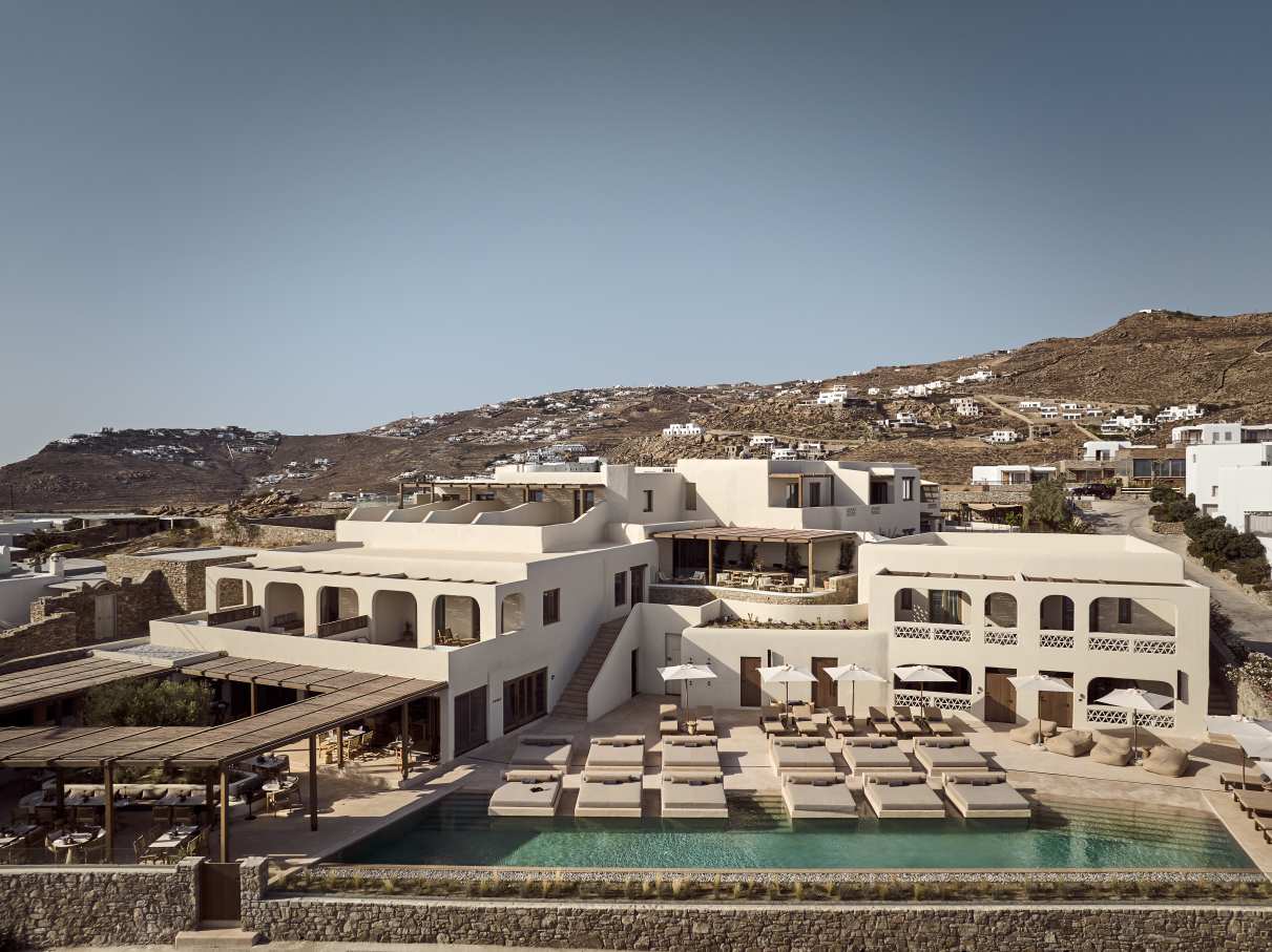 El interior de este complejo hotelero presenta una estética minimalista en tonos tierra, materiales de primera calidad y una iluminación tenue para crear una atmósfera relajante, propia de un spa. Los baños cuentan con una amplia encimera suspendida de mármol y un sobrio lavabo integrado, complementado con la elegante grifería Cala en negro mate, que crea un llamativo contraste con los tonos más claros del mármol y las paredes.2