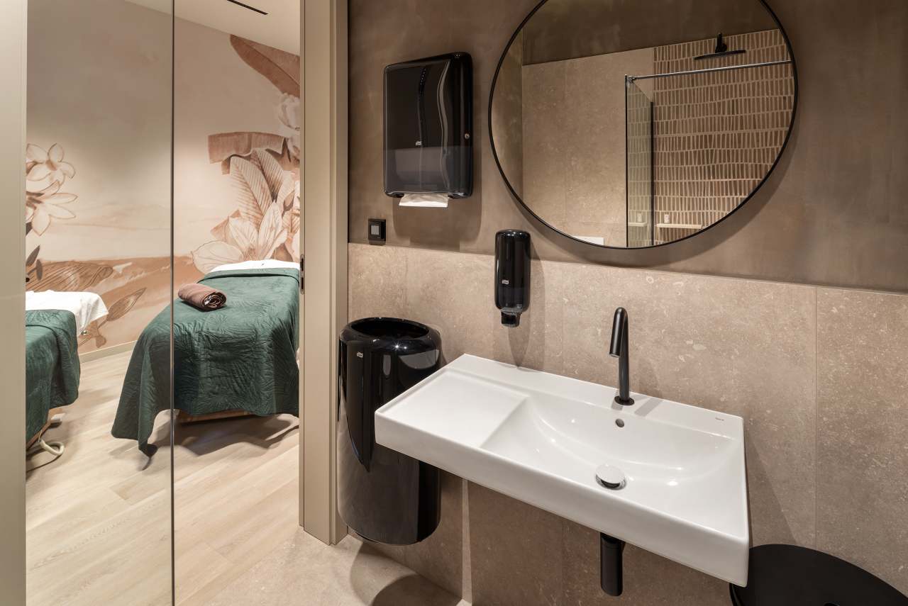 La prioridad en el diseño interior del hotel es garantizar que los huéspedes se vayan con una sonrisa, sintiéndose relajados y completamente satisfechos. Adoptando el enfoque minimalista del hygge, el diseño transmite una agradable sensación de confort a través de una cuidada selección de colores y mobiliario en materiales naturales con suaves curvas y formas orgánicas. En perfecta sintonía con la filosofía hygge, las líneas suaves y las formas redondeadas del lavabo Beyond de color café y del inodoro y bidé Inspira irradian relajación, calidez y armonía. El diseño de la colección Ona, inspirado en la naturaleza, se suma a la estética relajante. Los bidés y lavabos suspendidos contribuyen a crear una sensación de amplitud y equilibrio que evoca la serenidad de los paisajes tranquilos. De esta forma, el confort y el hygge se transmiten a todos los huéspedes del hotel. Los aseos públicos para hombres cuentan con los minimalistas urinarios Proton y los aseos accesibles están equipados con inodoros Access y asas de baño, garantizando un entorno acogedor e inclusivo para todos.16