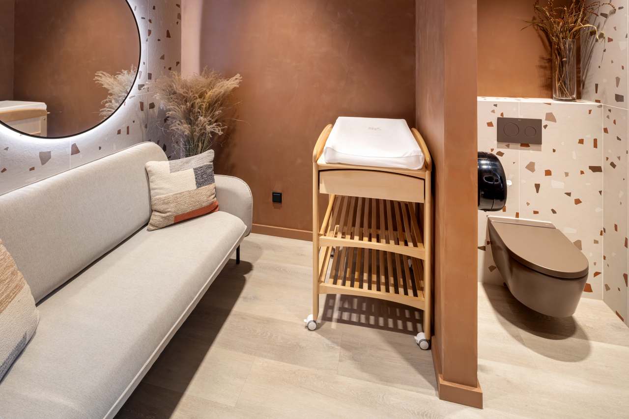 La prioridad en el diseño interior del hotel es garantizar que los huéspedes se vayan con una sonrisa, sintiéndose relajados y completamente satisfechos. Adoptando el enfoque minimalista del hygge, el diseño transmite una agradable sensación de confort a través de una cuidada selección de colores y mobiliario en materiales naturales con suaves curvas y formas orgánicas. En perfecta sintonía con la filosofía hygge, las líneas suaves y las formas redondeadas del lavabo Beyond de color café y del inodoro y bidé Inspira irradian relajación, calidez y armonía. El diseño de la colección Ona, inspirado en la naturaleza, se suma a la estética relajante. Los bidés y lavabos suspendidos contribuyen a crear una sensación de amplitud y equilibrio que evoca la serenidad de los paisajes tranquilos. De esta forma, el confort y el hygge se transmiten a todos los huéspedes del hotel. Los aseos públicos para hombres cuentan con los minimalistas urinarios Proton y los aseos accesibles están equipados con inodoros Access y asas de baño, garantizando un entorno acogedor e inclusivo para todos.17