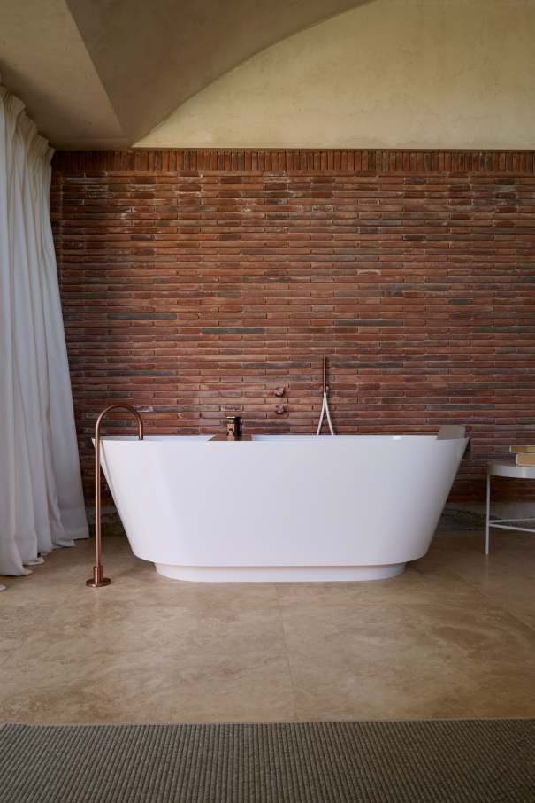 La distribución de Casa IV transforma el baño en un elemento fluido del espacio vital, contribuyendo a mejorar la experiencia de los habitantes de la vivienda. La incorporación de la bañera, el inodoro y el lavabo sobre encimera de la colección Tura genera una sensación de calma y sofisticación, mientras que la grifería Stripes de la colección Nu introduce un toque de dinamismo. La bañera trasciende lo funcional, convirtiéndose en el centro de atención del dormitorio y en un símbolo del estilo de vida mediterráneo. Esta vivienda es un ejemplo de cómo los productos Roca mejoran la experiencia de los usuarios, creando una mezcla perfecta de funcionalidad y diseño, en línea con la filosofía del proyecto, basada en la elegancia discreta y en los detalles cuidadosamente escogidos.17