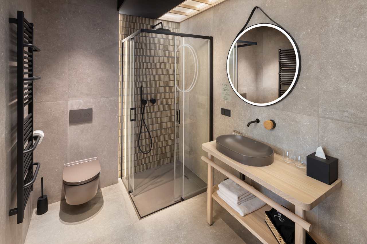 La prioridad en el diseño interior del hotel es garantizar que los huéspedes se vayan con una sonrisa, sintiéndose relajados y completamente satisfechos. Adoptando el enfoque minimalista del hygge, el diseño transmite una agradable sensación de confort a través de una cuidada selección de colores y mobiliario en materiales naturales con suaves curvas y formas orgánicas. En perfecta sintonía con la filosofía hygge, las líneas suaves y las formas redondeadas del lavabo Beyond de color café y del inodoro y bidé Inspira irradian relajación, calidez y armonía. El diseño de la colección Ona, inspirado en la naturaleza, se suma a la estética relajante. Los bidés y lavabos suspendidos contribuyen a crear una sensación de amplitud y equilibrio que evoca la serenidad de los paisajes tranquilos. De esta forma, el confort y el hygge se transmiten a todos los huéspedes del hotel. Los aseos públicos para hombres cuentan con los minimalistas urinarios Proton y los aseos accesibles están equipados con inodoros Access y asas de baño, garantizando un entorno acogedor e inclusivo para todos.1