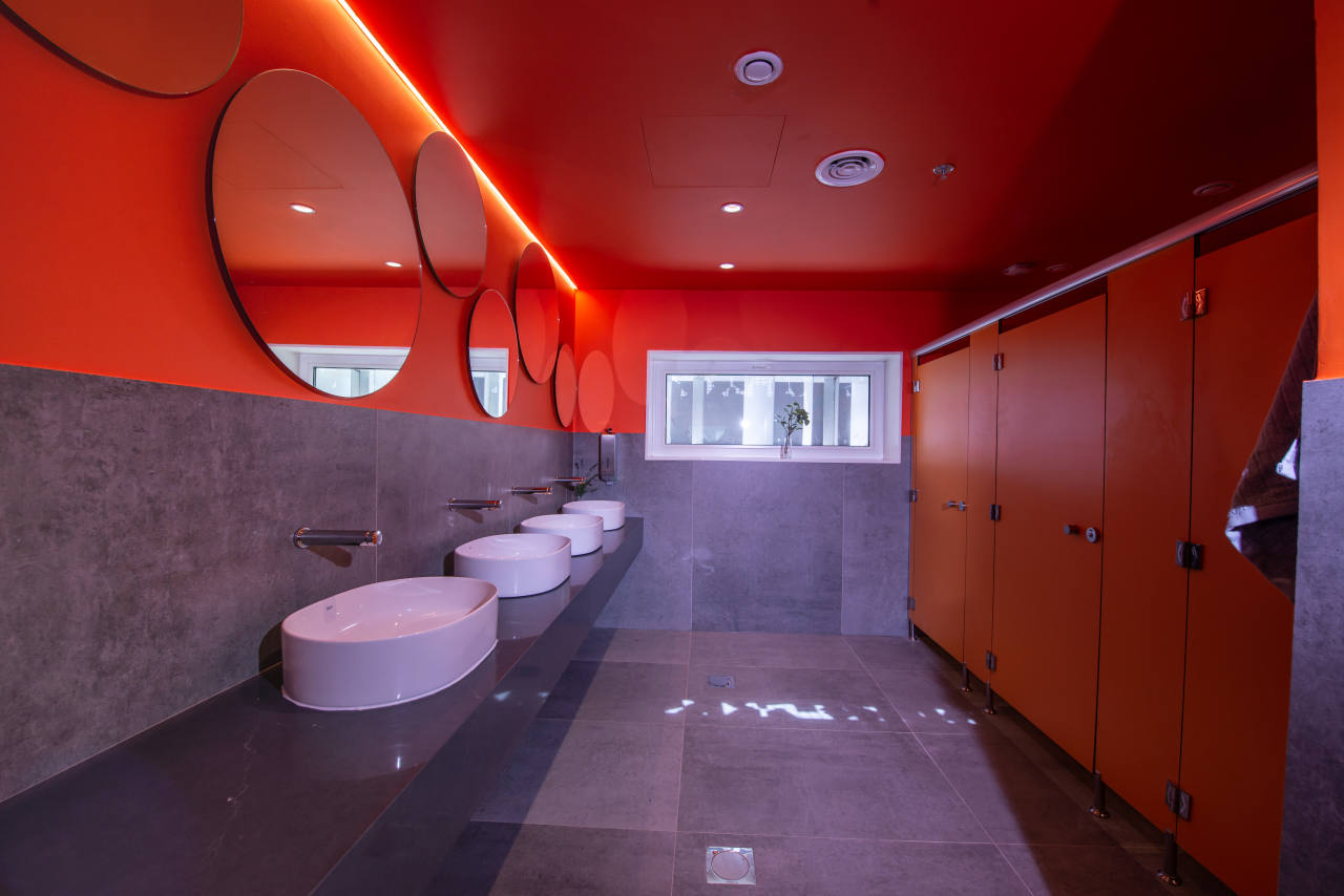 En línea con esta premisa, este espacio, caracterizado por su llamativo y colorido diseño, innovación y sostenibilidad, incorporó las soluciones de baño de Roca más avanzadas, mostrándolas al público. Una serie de vistosos conos aportaron sombra y ventilaron de forma natural el espacio; en su interior los inodoros Inspira y Beyond de Roca fueron el complemento perfecto a las formas fluidas del pabellón y los objetivos de sostenibilidad gracias a su tecnología de ahorro de agua. Por otro lado, los lavabos Inspira, los espejos Iridia y los separadores de urinario Wing replicaban la estética lúdica y sofisticada del entorno. Propuestas como la placa de accionamiento electrónica EP1 y la grifería temporizada Avant demostraron el compromiso de Roca con la eficiencia hídrica, reflejando a la perfección los principios de economía circular y la filosofía del diseño centrado en las personas.2