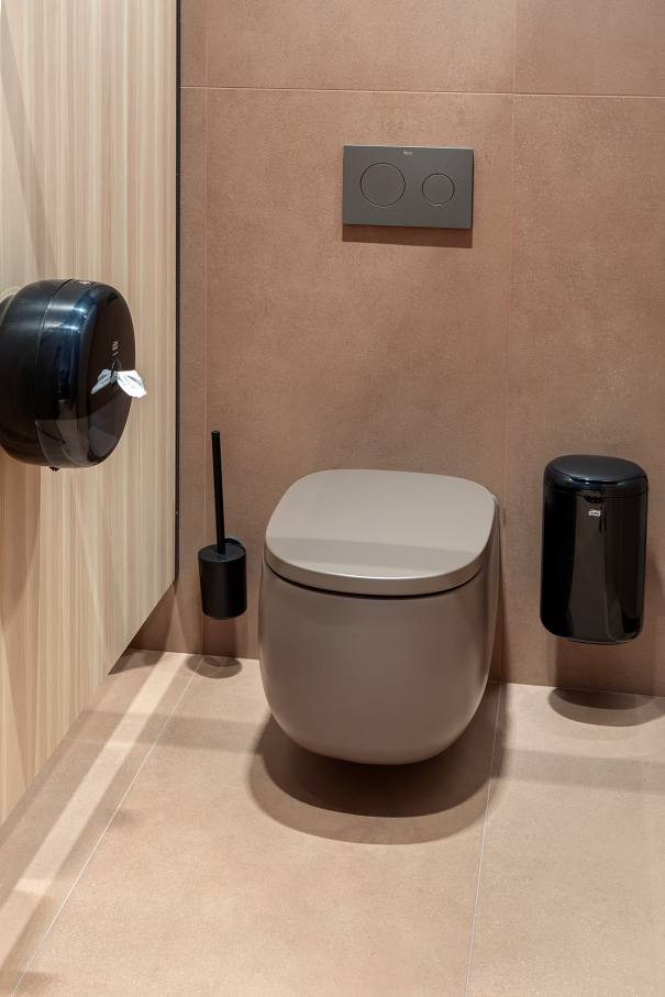 La prioridad en el diseño interior del hotel es garantizar que los huéspedes se vayan con una sonrisa, sintiéndose relajados y completamente satisfechos. Adoptando el enfoque minimalista del hygge, el diseño transmite una agradable sensación de confort a través de una cuidada selección de colores y mobiliario en materiales naturales con suaves curvas y formas orgánicas. En perfecta sintonía con la filosofía hygge, las líneas suaves y las formas redondeadas del lavabo Beyond de color café y del inodoro y bidé Inspira irradian relajación, calidez y armonía. El diseño de la colección Ona, inspirado en la naturaleza, se suma a la estética relajante. Los bidés y lavabos suspendidos contribuyen a crear una sensación de amplitud y equilibrio que evoca la serenidad de los paisajes tranquilos. De esta forma, el confort y el hygge se transmiten a todos los huéspedes del hotel. Los aseos públicos para hombres cuentan con los minimalistas urinarios Proton y los aseos accesibles están equipados con inodoros Access y asas de baño, garantizando un entorno acogedor e inclusivo para todos.29