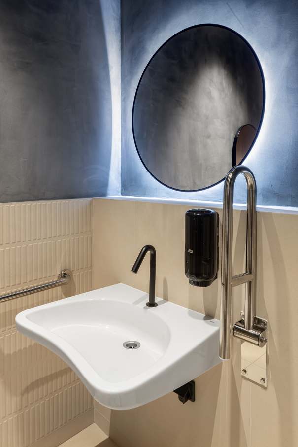 La prioridad en el diseño interior del hotel es garantizar que los huéspedes se vayan con una sonrisa, sintiéndose relajados y completamente satisfechos. Adoptando el enfoque minimalista del hygge, el diseño transmite una agradable sensación de confort a través de una cuidada selección de colores y mobiliario en materiales naturales con suaves curvas y formas orgánicas. En perfecta sintonía con la filosofía hygge, las líneas suaves y las formas redondeadas del lavabo Beyond de color café y del inodoro y bidé Inspira irradian relajación, calidez y armonía. El diseño de la colección Ona, inspirado en la naturaleza, se suma a la estética relajante. Los bidés y lavabos suspendidos contribuyen a crear una sensación de amplitud y equilibrio que evoca la serenidad de los paisajes tranquilos. De esta forma, el confort y el hygge se transmiten a todos los huéspedes del hotel. Los aseos públicos para hombres cuentan con los minimalistas urinarios Proton y los aseos accesibles están equipados con inodoros Access y asas de baño, garantizando un entorno acogedor e inclusivo para todos.42